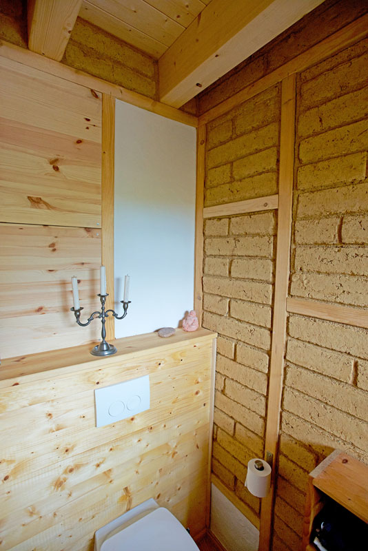 Gäste WC mit Lehm Sichtmauer, Lehmverputz und WC Vorwand in Holz mit Leinöl (Quelle: Aufnahme Florian Lohmann)